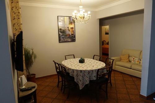 a dining room with a table with chairs and a couch at Herois Apartment in Damaia