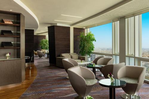 a lobby with chairs and tables and large windows at Four Points By Sheraton Kuwait in Kuwait