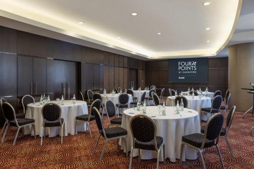 a conference room with white tables and chairs and a sign at Four Points By Sheraton Kuwait in Kuwait