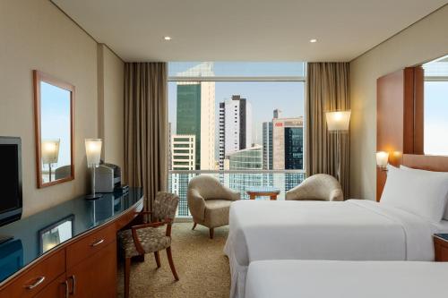 a hotel room with two beds and a large window at Four Points By Sheraton Kuwait in Kuwait