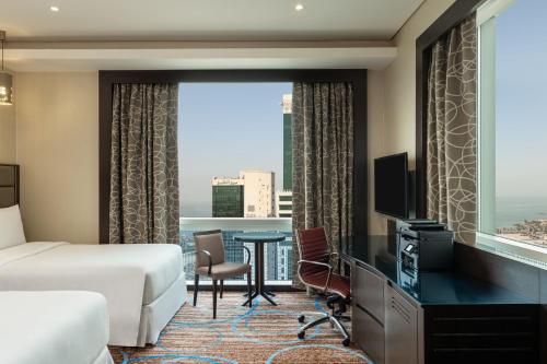 a hotel room with a bed and a large window at Four Points By Sheraton Kuwait in Kuwait