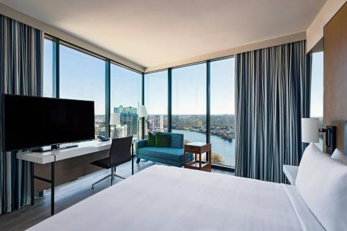 um quarto de hotel com uma cama e uma secretária com uma televisão em Austin Marriott Downtown em Austin