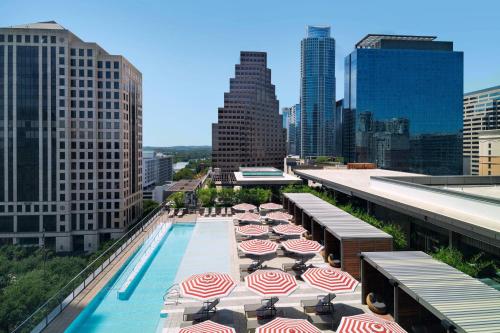 a pool with umbrellas and chairs on top of a building at Austin Marriott Downtown in Austin