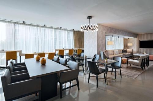 a restaurant with tables and chairs and a living room at Austin Marriott Downtown in Austin