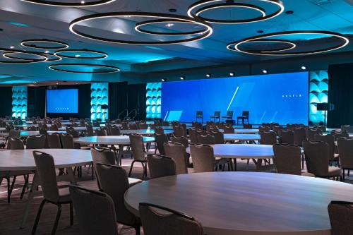 a conference room with tables and chairs and a projection screen at Austin Marriott Downtown in Austin
