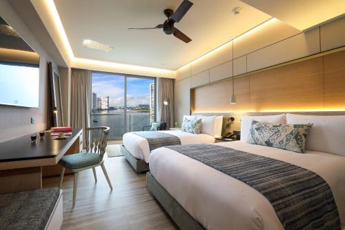 Renaissance Cancun Resort & Marina في كانكون: غرفة فندقية بسريرين ومكتب