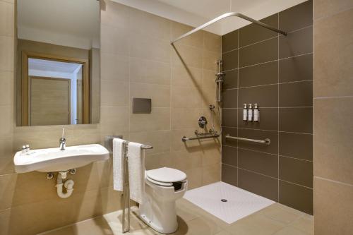 a bathroom with a toilet and a sink and a shower at AC Hotel by Marriott Milan Sesto in Sesto San Giovanni