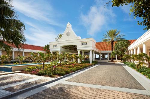duży biały budynek z wieżą zegarową w obiekcie Curaçao Marriott Beach Resort w mieście Willemstad
