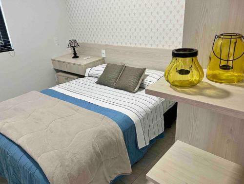 a bedroom with a bed and a yellow vase at Apartamento em foz do Iguaçu in Foz do Iguaçu