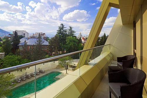 a balcony with a view of a swimming pool at Sheraton Grand Tbilisi Metechi Palace in Tbilisi City