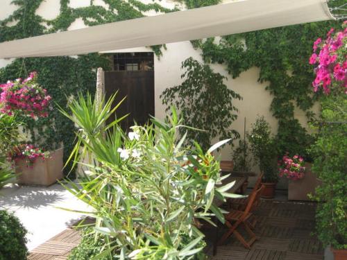 a patio with a bunch of plants and a white umbrella at B&B Casa Zia Cianetta Residenza di Campagna in Capodacqua di Foligno
