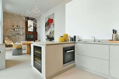 a kitchen with white cabinets and a chandelier at 5 Terrazze Exlusive Apartments in Gargnano