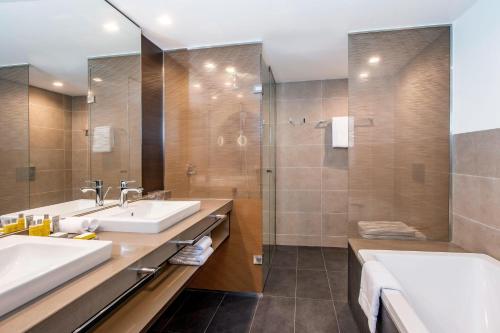 a bathroom with two sinks and a shower at Sheraton Grand Tbilisi Metechi Palace in Tbilisi City