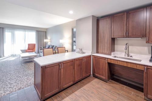 a kitchen with wooden cabinets and a living room at Auburn Marriott Opelika Resort & Spa at Grand National in Opelika