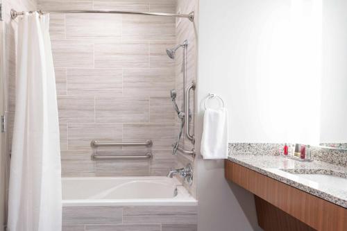 a bathroom with a bath tub and a sink at Auburn Marriott Opelika Resort & Spa at Grand National in Opelika