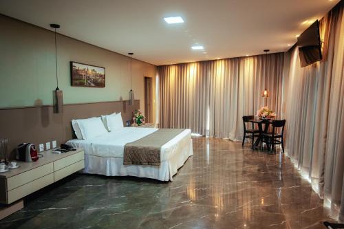 Bacabal的住宿－Roma Hotel，酒店客房配有一张床铺和一张桌子。