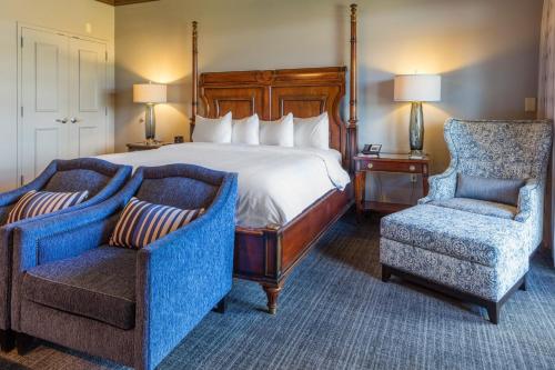 ein Hotelzimmer mit einem Bett und zwei Stühlen in der Unterkunft Auburn Marriott Opelika Resort & Spa at Grand National in Opelika