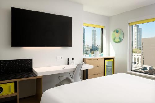 a bedroom with a bed and a desk with a flat screen tv at Astra Hotel, Seattle, a Tribute Portfolio Hotel in Seattle