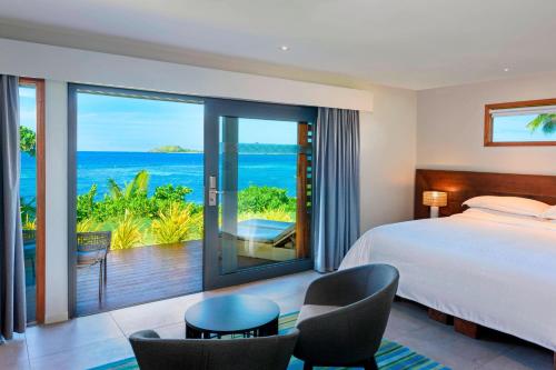 a bedroom with a bed and a view of the ocean at Sheraton Resort & Spa, Tokoriki Island, Fiji in Tokoriki