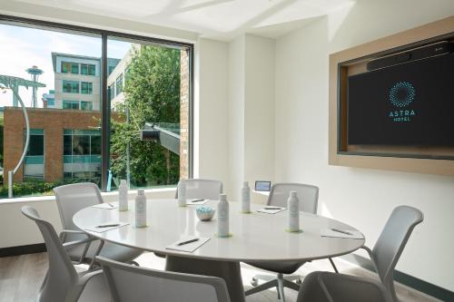 a meeting room with a table and chairs and a tv at Astra Hotel, Seattle, a Tribute Portfolio Hotel in Seattle