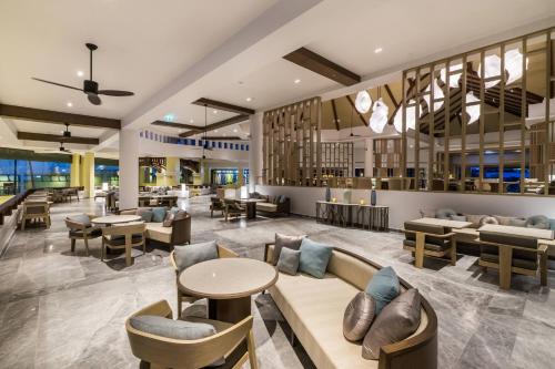 a lobby of a hotel with tables and chairs at Phuket Marriott Resort & Spa, Merlin Beach in Patong Beach