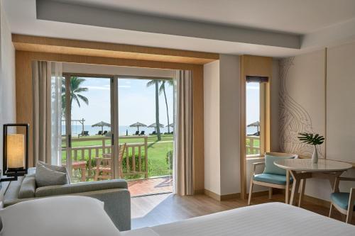 a hotel room with a bed and a view of the ocean at Phuket Marriott Resort & Spa, Merlin Beach in Patong Beach