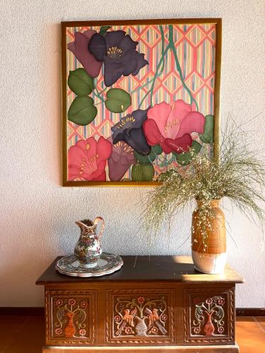 a painting on the wall above a table with a vase at Beachfront Villa Rodi Pelion in Kato Gatzea