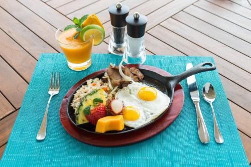 a plate of food with eggs and fruit on a table at The Westin Hapuna Beach Resort in Hapuna Beach