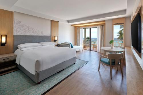 een slaapkamer met een groot bed en een bureau met een bureau bij Phuket Marriott Resort & Spa, Merlin Beach in Patong Beach