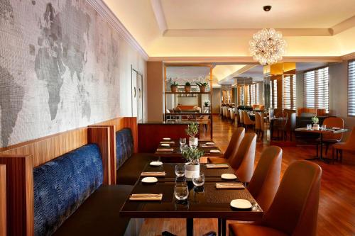 a restaurant with tables and chairs and a map on the wall at The Westin Palace, Milan in Milan