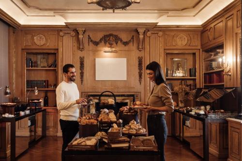 a man and woman standing in front of a table with food at The Westin Palace, Milan in Milan