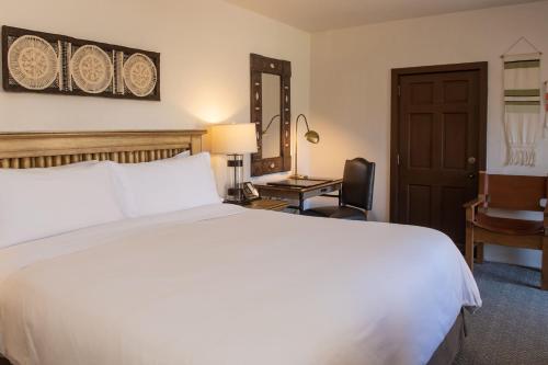a bedroom with a large white bed and a desk at La Posada De Santa Fe, a Tribute Portfolio Resort & Spa in Santa Fe