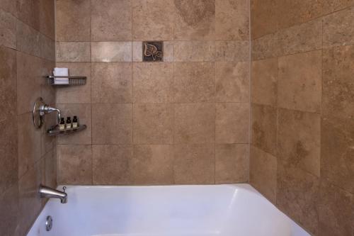 a bath tub in a bathroom with a shower at La Posada De Santa Fe, a Tribute Portfolio Resort & Spa in Santa Fe
