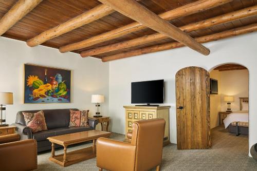 a living room with a couch and a tv at La Posada De Santa Fe, a Tribute Portfolio Resort & Spa in Santa Fe