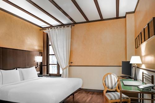 a hotel room with a bed and a desk and a window at AC Hotel Ciudad de Tudela by Marriott in Tudela