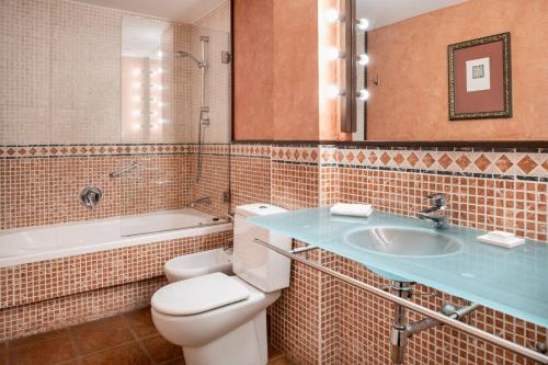 a bathroom with a toilet and a sink and a tub at AC Hotel Ciudad de Tudela by Marriott in Tudela