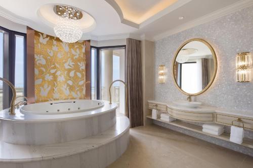 baño con bañera grande y espejo grande en Sheraton Grand Danang Resort & Convention Center, en Da Nang