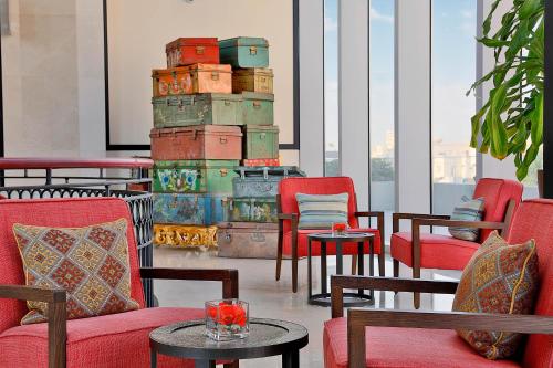 أصيلة أحد فنادق لاكشري كولكشن جدة في جدة: غرفة بها كراسي وطاولات ومجموعة من الأمتعة