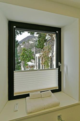 a window with two towels sitting on a window sill at 5 Terrazze Exlusive Apartments in Gargnano