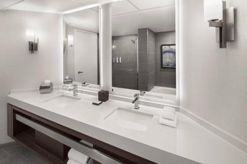 a white bathroom with two sinks and a shower at Minneapolis Marriott City Center in Minneapolis