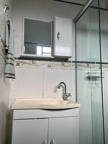 a bathroom with a sink and a window at Loft em Foz do Iguaçu in Foz do Iguaçu