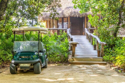 a golf cart parked in front of a wooden walkway at North Island, a Luxury Collection Resort, Seychelles in North Island