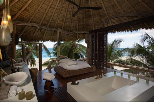 a bathroom with a tub and a bed in a resort at North Island, a Luxury Collection Resort, Seychelles in North Island