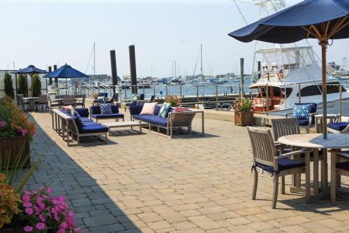 a patio with tables and chairs and a boat at Newport Marriott Hotel & Spa in Newport