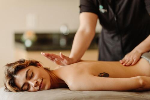 a woman getting a back massage from a therapist at Newport Marriott Hotel & Spa in Newport