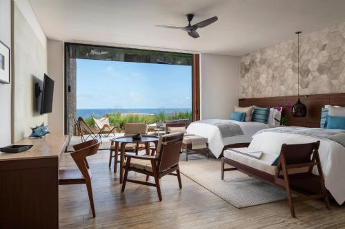 Schlafzimmer mit einem Bett, einem Tisch und Stühlen in der Unterkunft Zadún, a Ritz-Carlton Reserve in San José del Cabo