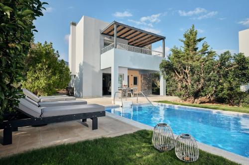 eine Villa mit einem Pool und einem Haus in der Unterkunft Domes of Elounda, Autograph Collection in Elounda