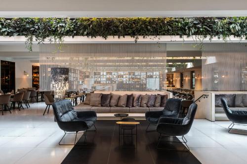 eine Lobby mit einem Sofa, Stühlen und Tischen in der Unterkunft Le Méridien Vienna in Wien