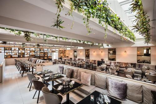 a restaurant with tables and chairs and books at Le Méridien Vienna in Vienna