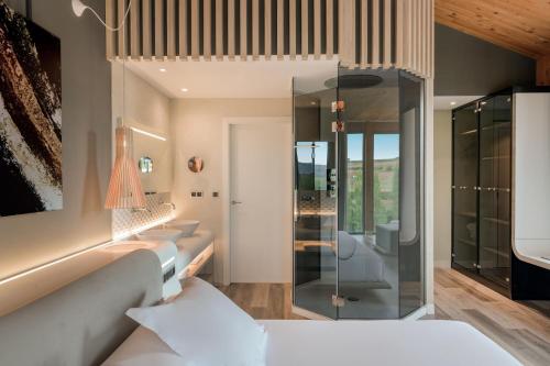 1 dormitorio con cama blanca y ducha acristalada en Palacio Tondón, La Rioja Brinas, Autograph Collection, en Briñas